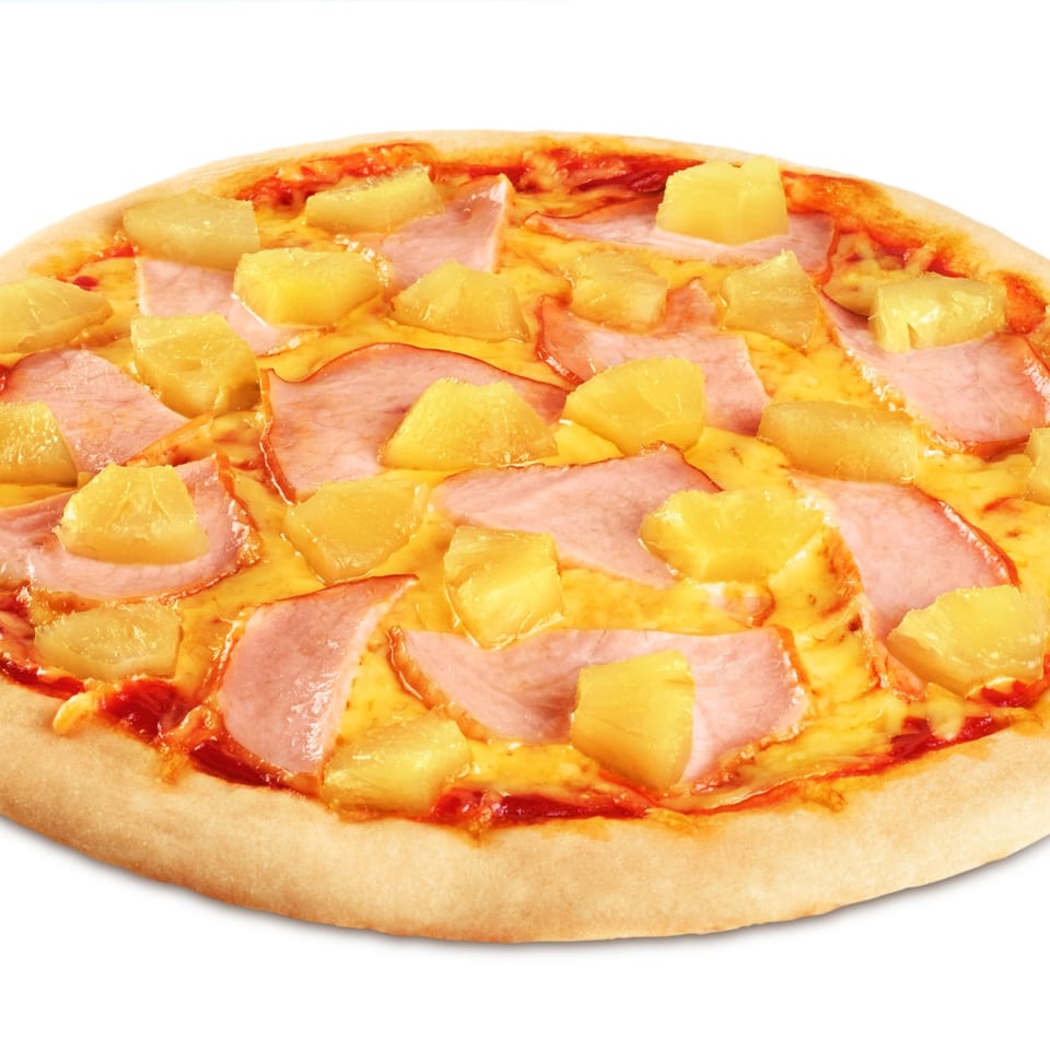Pizza topped with ham and pineapple on a white background.